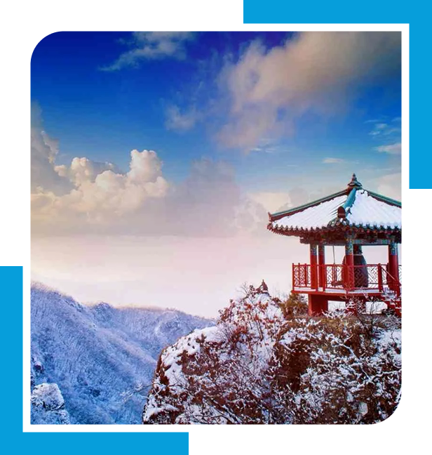 Snowy mountain scene with a pagoda on a cliff.